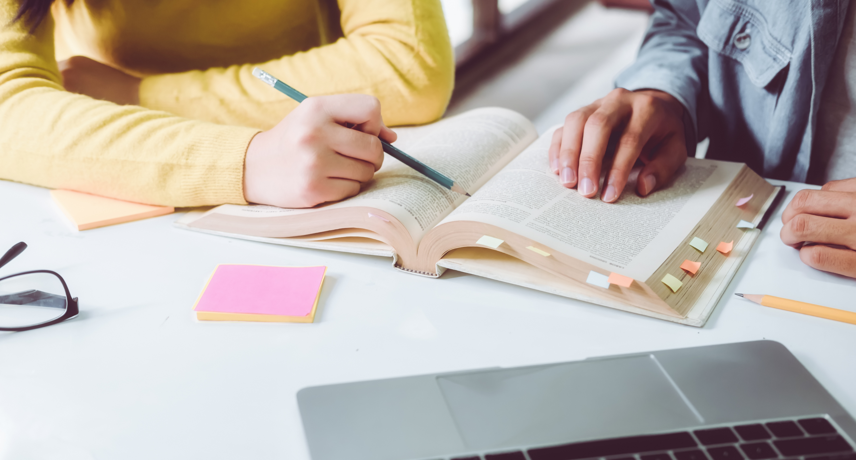 School book on table with sticky notes and pencil