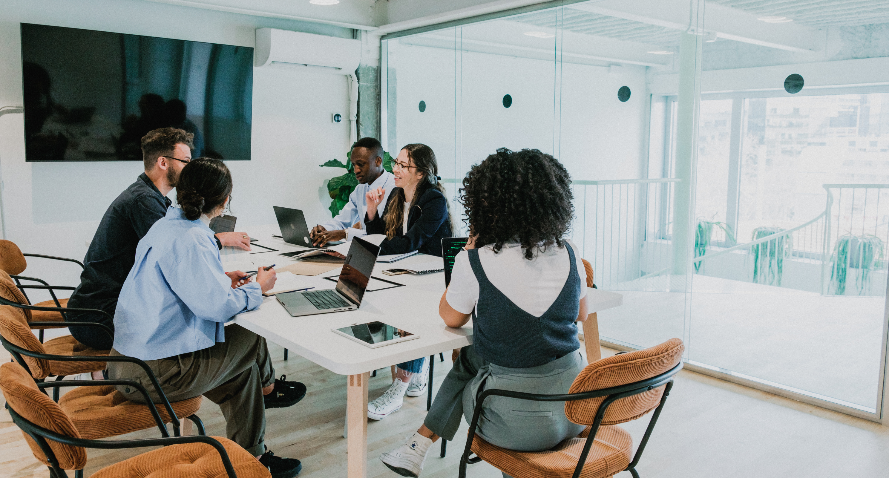 Finance team gathered in meeting room in modern office