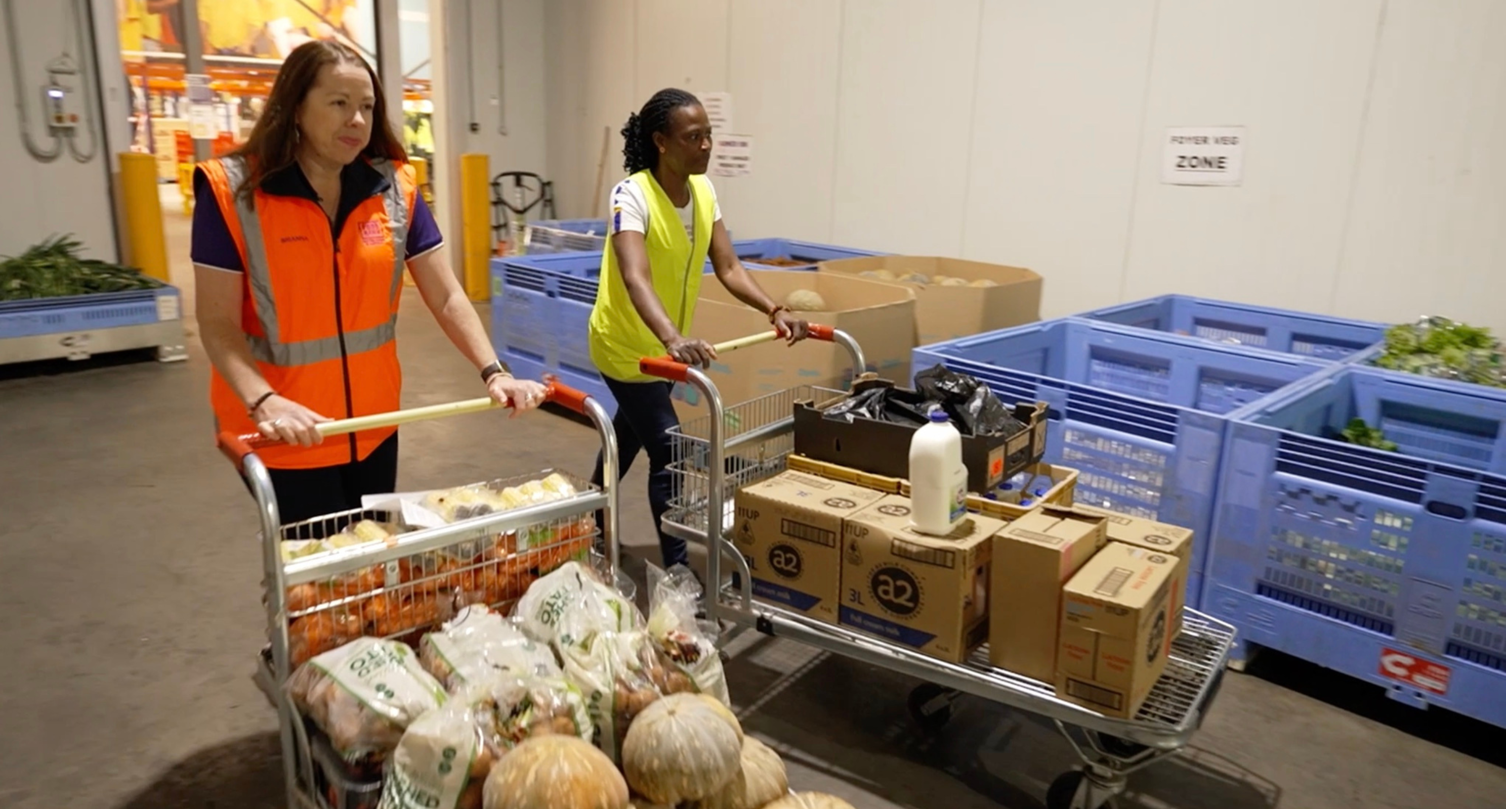 Workers pushing trollies containing food for foodbank truck