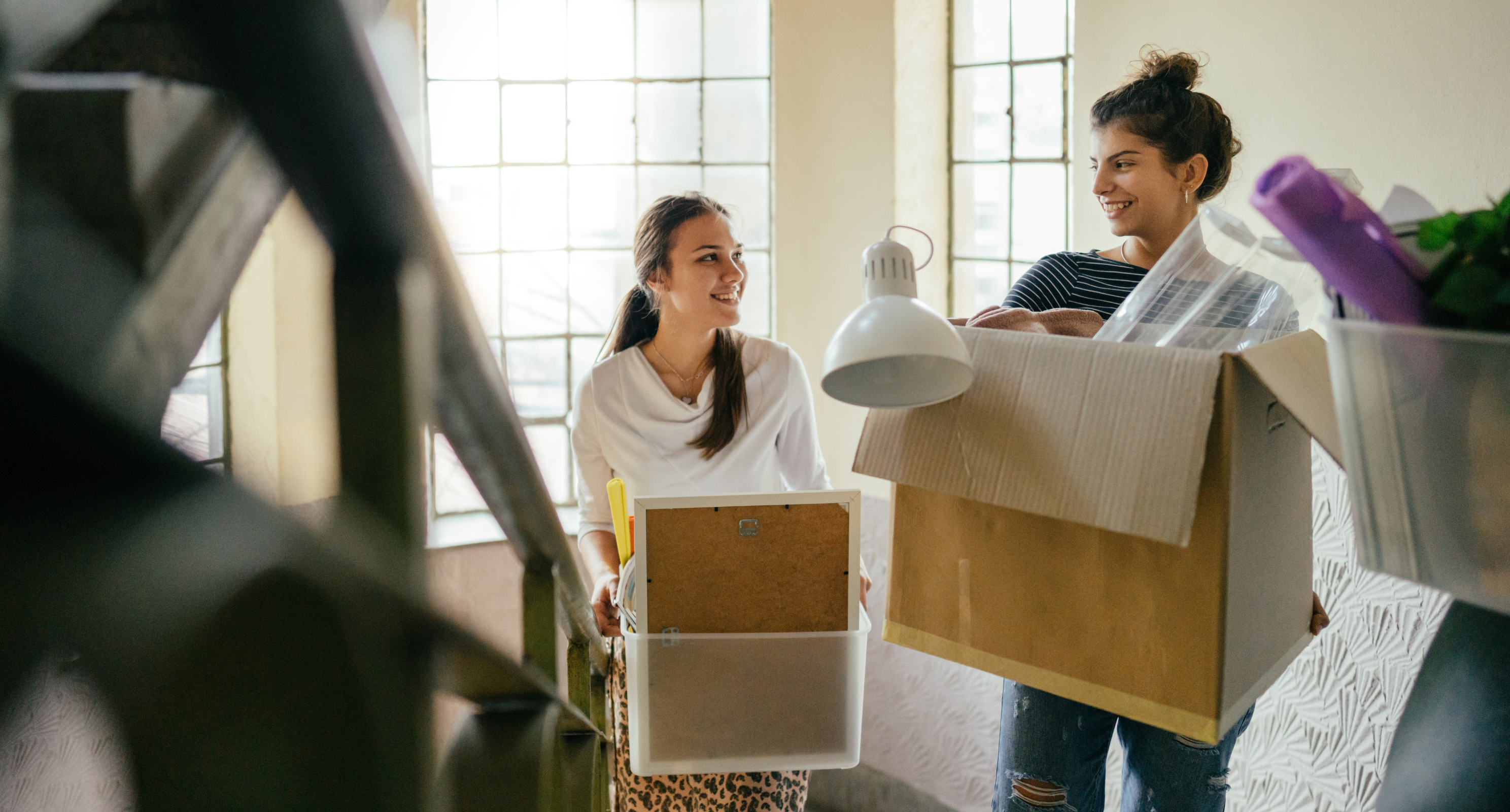 Young adults carrying moving boxes