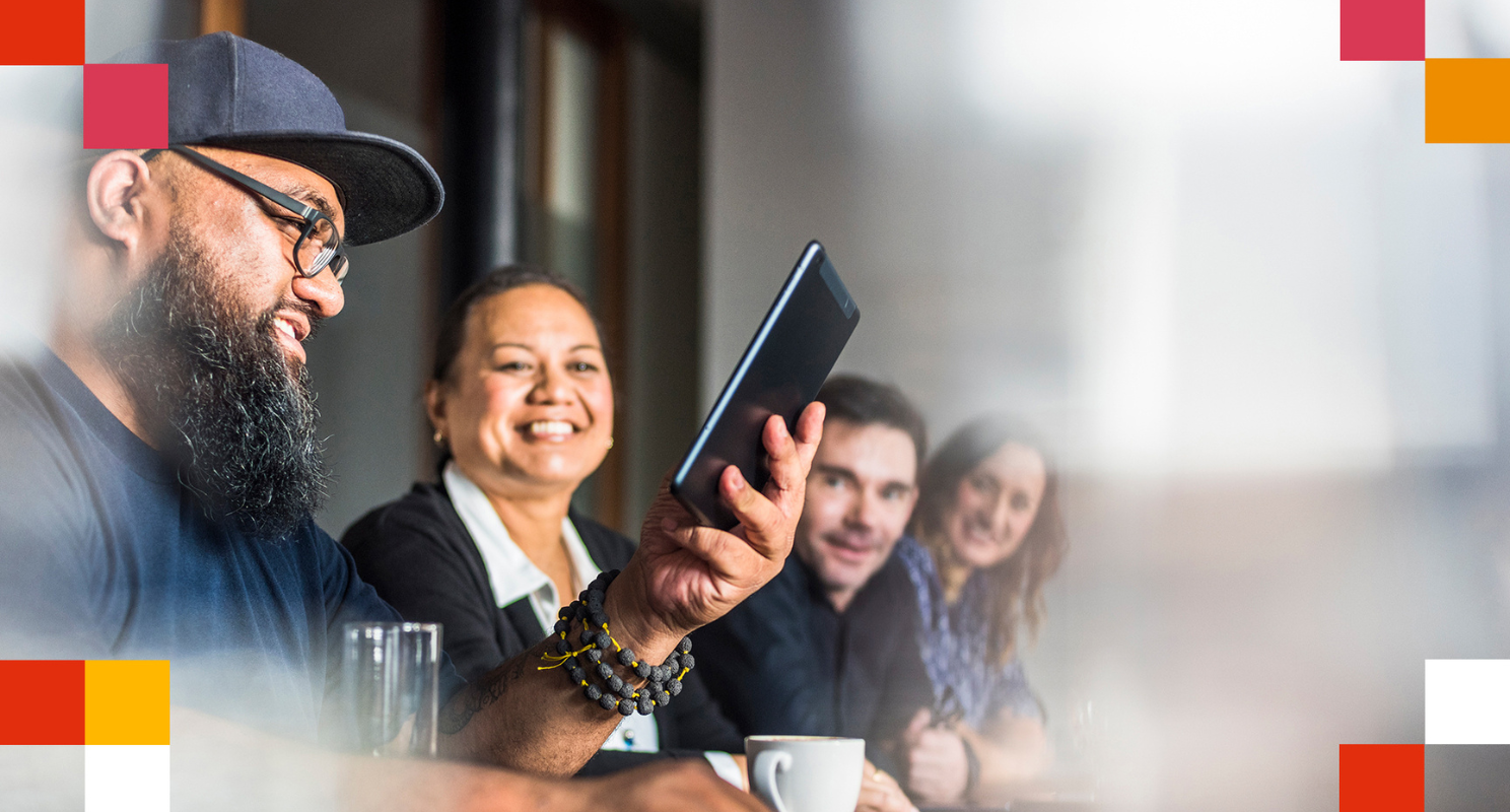 PwC team in a meeting looking at an iPad