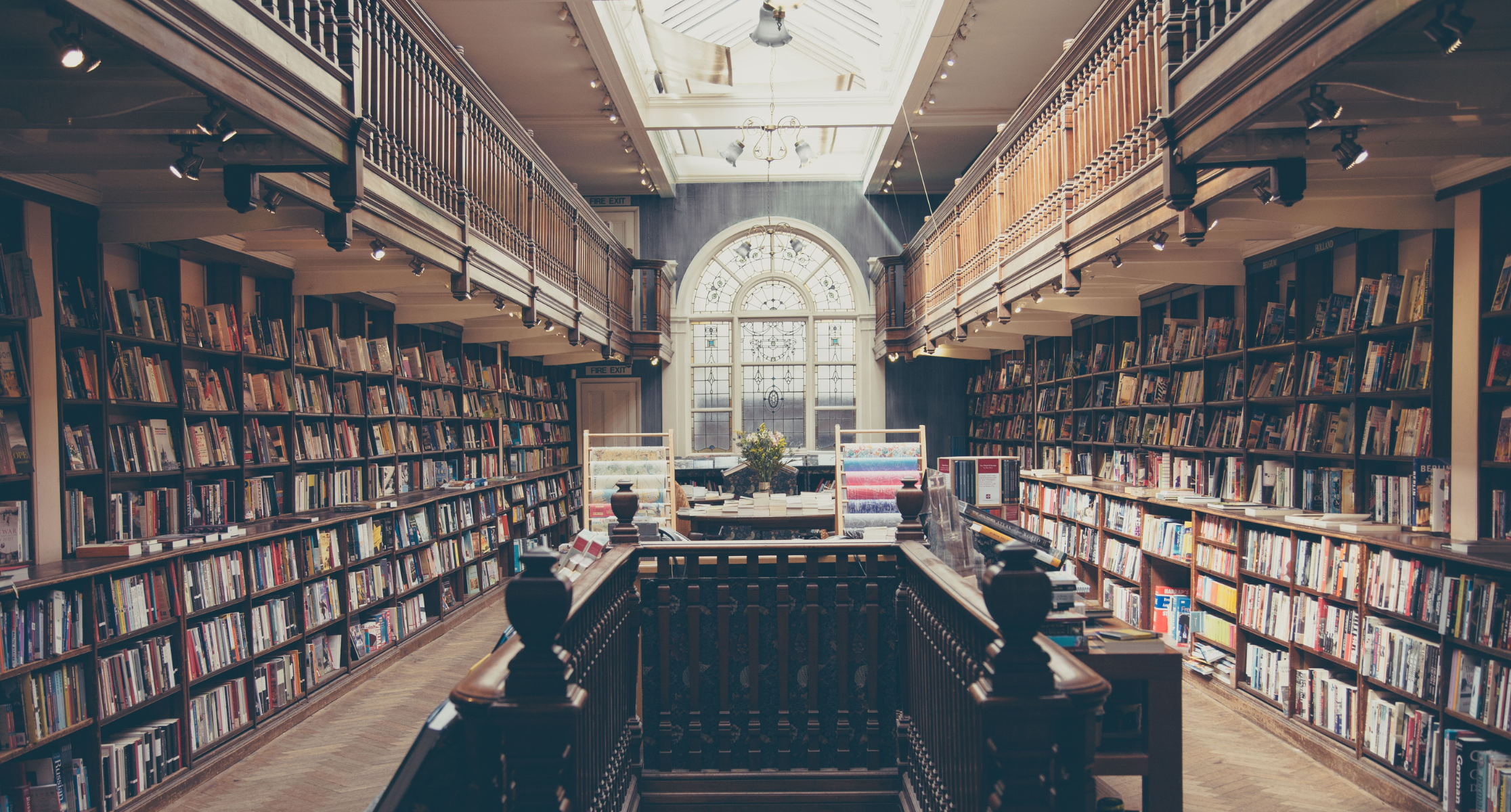 Old fashioned, wooden library with staircase and tall shelves of books