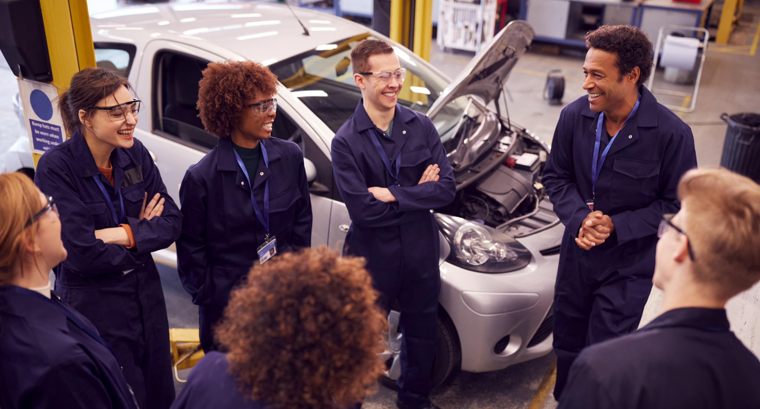 group of auto apprentices laughing in garage