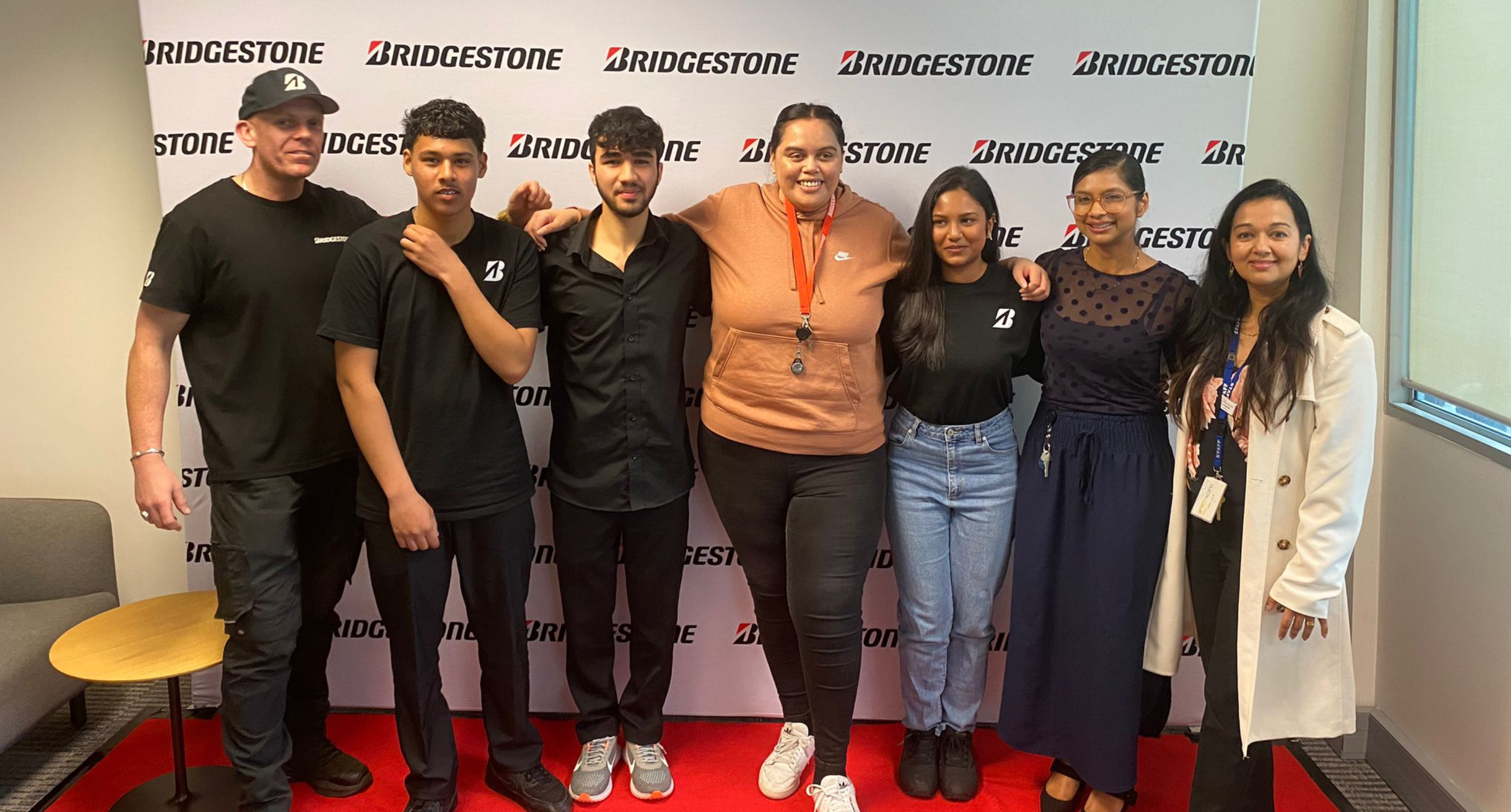 Bridgestone NZ team posing in front of media wall