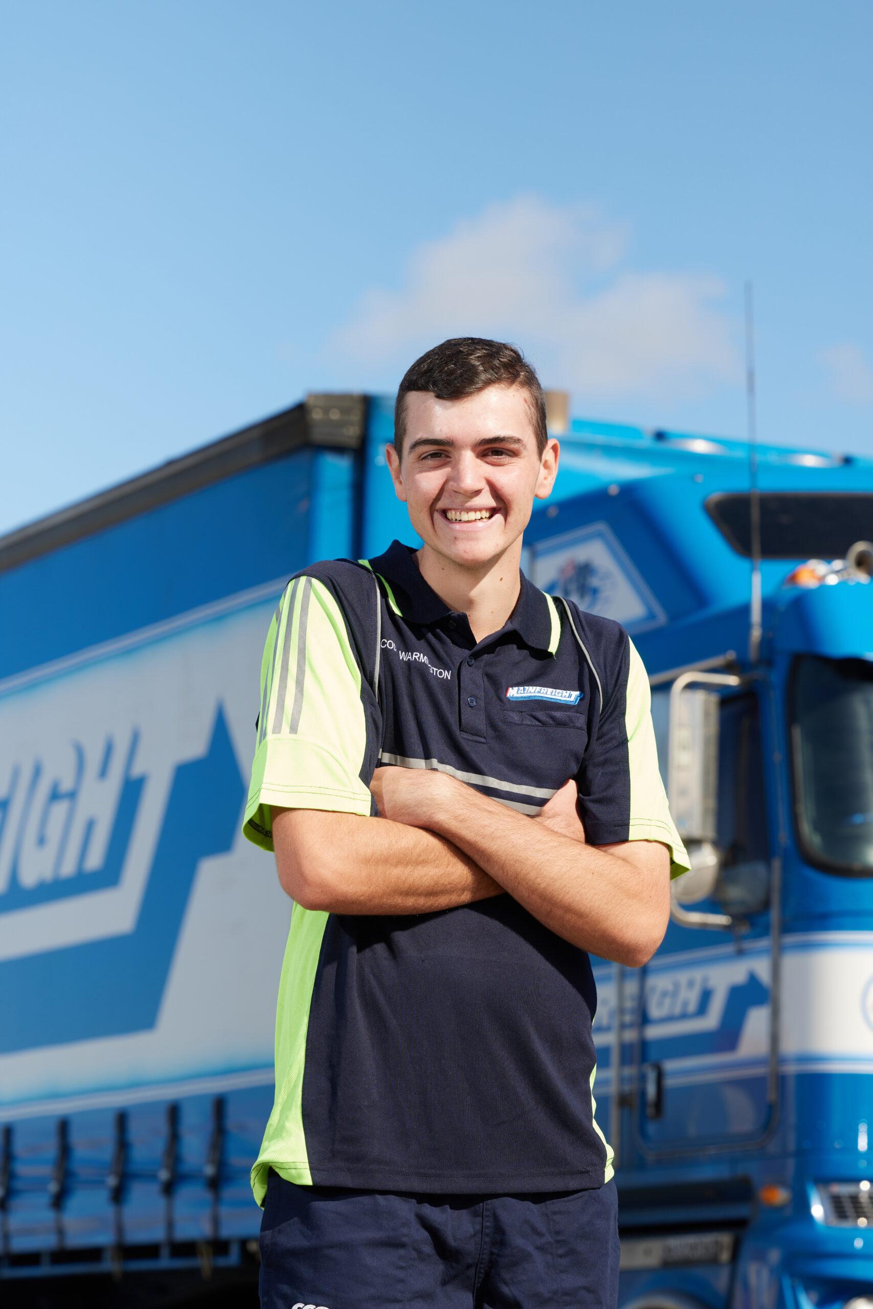 young male Mainfreight Cadet smilng with arms folded