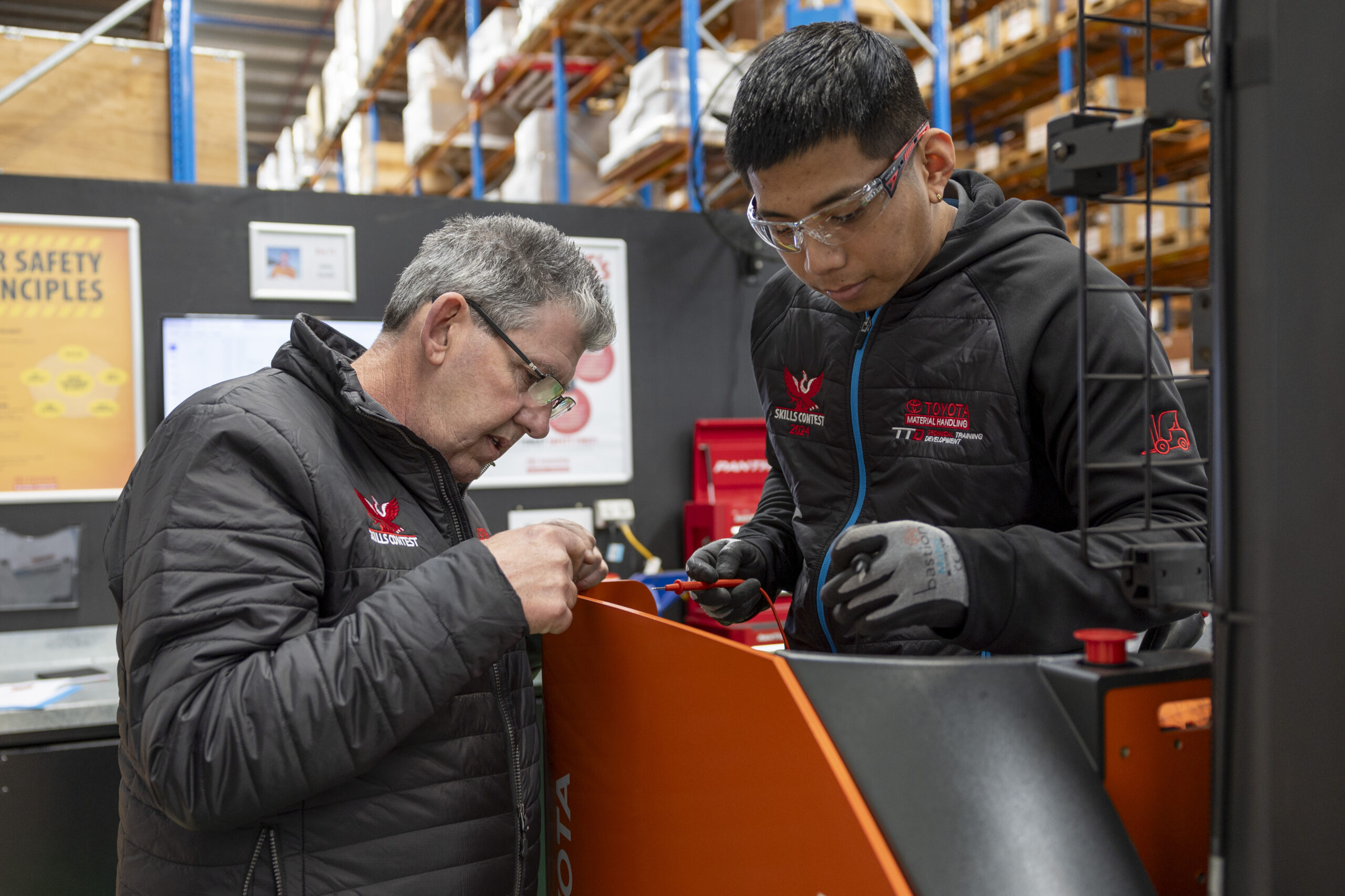 Two heavy vehicle mechanics in workshop