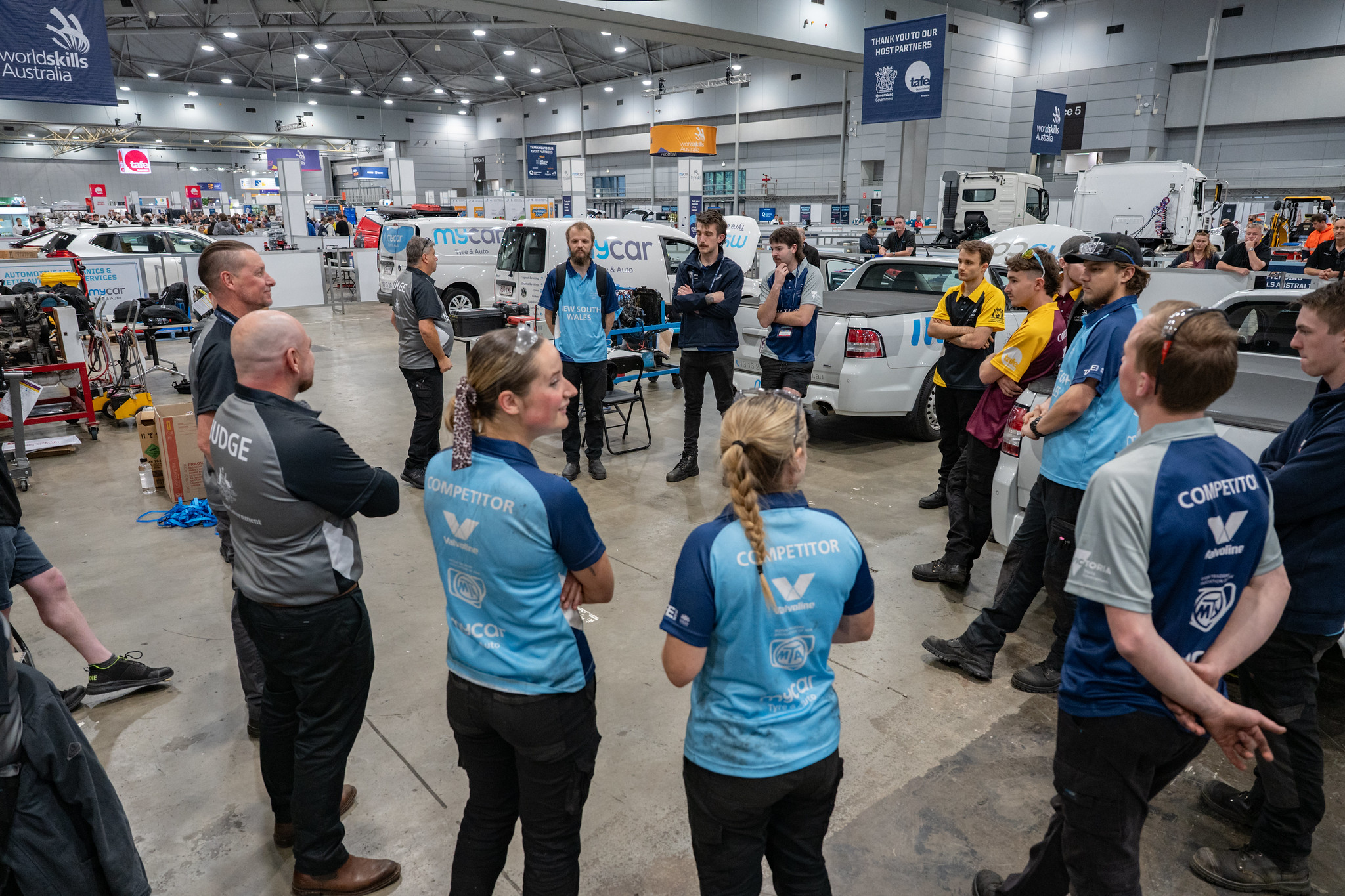 young automotive mechanics stood in a circle at WorldSKills