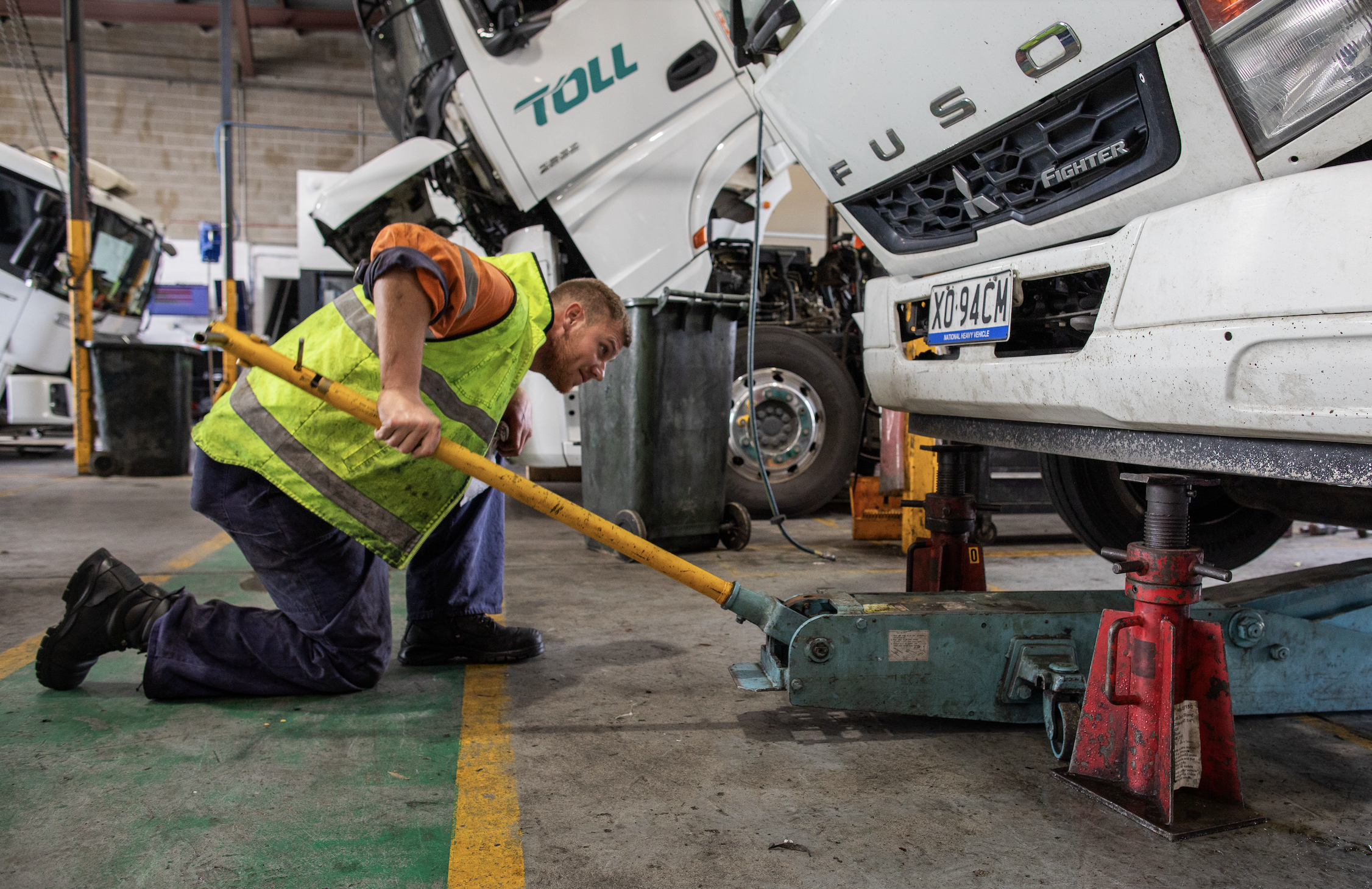mechanic using car jack in warehouse